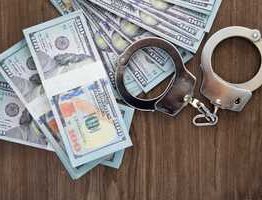 Man in handcuffs holding money