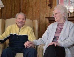 two seniors holding hands and laughing