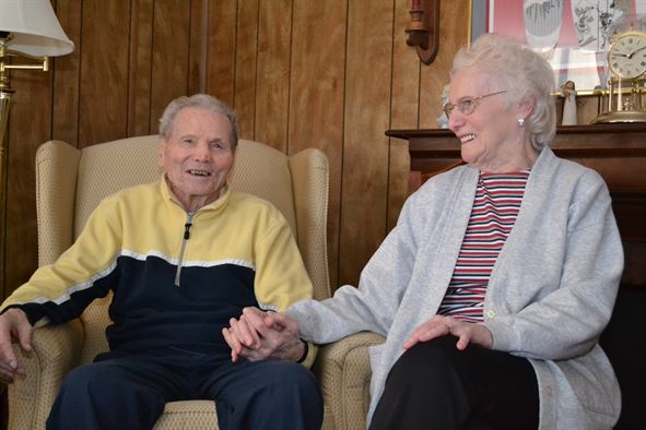 two seniors holding hands and laughing