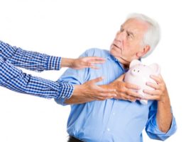 Old man holding onto piggy bank