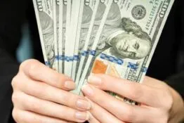 Person holding hundred dollar bills