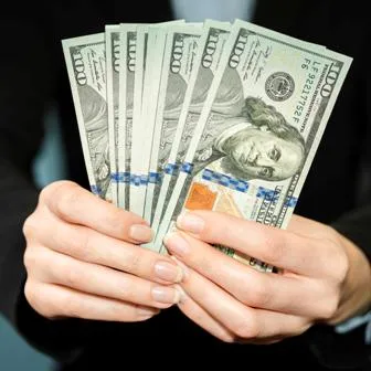 Person holding hundred dollar bills
