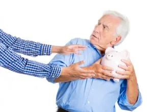 Old man holding onto piggy bank