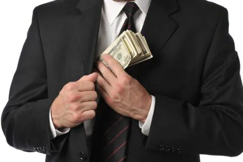 image of man slipping cash payoff